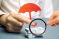 An insurance agent holds a red umbrella over dollar bills. Savings protection. Keeping money safe. Investment and capital Royalty Free Stock Photo