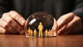 Insurance agent protecting family in crystal ball on table, closeup Royalty Free Stock Photo
