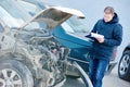 Insurance agent recording car damage on claim form Royalty Free Stock Photo