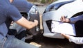 Insurance agents inspect for damage to cars that collide on the road to claim compensation from driving accidents Royalty Free Stock Photo