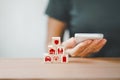 Insurance concept, wooden block with security on top of pyramid shape on wood table and blurred senior woman holding white Royalty Free Stock Photo