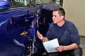 Insurance expert working at damaged car