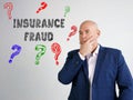 INSURANCE FRAUD question marks phrase on the gray wall