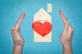 Insurance home concept. House from wooden bricks inside hands. House with red heart. Love in home concept. Protection home Royalty Free Stock Photo