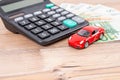 Insurance, loan and buying car concept. Red car and euro banknotes. Calculator, euro money and red car. Copy space for text. Royalty Free Stock Photo