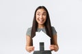 Insurance, loan, real estate and family concept. Smiling happy asian woman found perfect home, holding paper house and