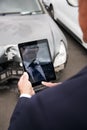 Insurance Loss Adjuster Taking Picture With Digital Tablet Of Damage To Car From Motor Accident Royalty Free Stock Photo