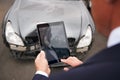 Insurance Loss Adjuster Taking Picture With Digital Tablet Of Damage To Car From Motor Accident Royalty Free Stock Photo