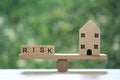 Insurance, Model house and Wording risk on wood block on natural green background, Business investment and Risk management concept