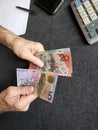 hands of an older man counting australian banknotes