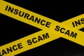 Insurance scam and fraud alert, caution and warning concept. Barricade tape with word in dark black background. Royalty Free Stock Photo