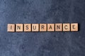 `Insurance` spelled out in wooden letter tiles