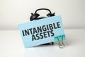 intangible assets is written in a blue sticker near a black alarm clock Royalty Free Stock Photo