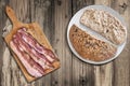 Bacon Rashers On Cutting Board And Integral Brown Bread Loaf Set On Old Weathered Cracked Flaky Wooden Picnic Table