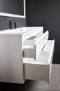 Integrated basin white countertop bathroom with horizontal drawer with sliding pull out shelves. White industrial flat Royalty Free Stock Photo