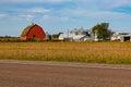 Integrated farm with tractor shed, farm house, old Red wooden barn with rusty corrugated roof, grain elevator. Royalty Free Stock Photo