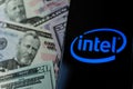 Intel logo on a smartphone and money. Concept for profit