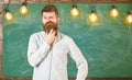 Intellectual task concept. Bearded hipster in shirt, chalkboard on background. Man with beard and mustache on thoughtful