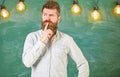 Intellectual task concept. Man with beard and mustache on thoughtful face stand in front of chalkboard. Guy thinking Royalty Free Stock Photo