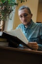 Intelligent male hipster student reading book and sitting at the table in public university library. Side view shot of Royalty Free Stock Photo