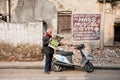 Intelligent man reading the latest news in a newspaper, standing on dirty street of town