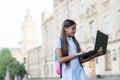 Intelligent teen girl work on laptop online in school yard, education and childhood development