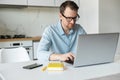 Intelligent young man wearing stylish eyewear working remotely from home Royalty Free Stock Photo