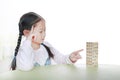 Intend little Asian child girl thinking to playing wood blocks tower game for Brain and Physical development skill in a classroom Royalty Free Stock Photo