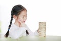 Intend little Asian child girl thinking to playing wood blocks tower game for Brain and Physical development skill in a classroom Royalty Free Stock Photo