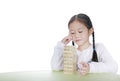 Intend little Asian child girl thinking to playing wood blocks tower game for Brain and Physical development skill in a classroom Royalty Free Stock Photo