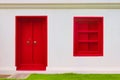 Intense blood red painted door and window on a white wall. Saturated, bold color, high contrast image. Royalty Free Stock Photo