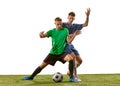 Two soccer players in action, motion on green grass flooring isolated over white background. Concept of global sport