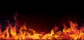 Intense red and yellow fire flames create a Seamless border on a black background. Royalty Free Stock Photo