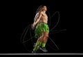 Intensity of a training session. Dynamic energy of muscular man training shirtless, jumping rope against black Royalty Free Stock Photo