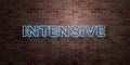 INTENSIVE - fluorescent Neon tube Sign on brickwork - Front view - 3D rendered royalty free stock picture