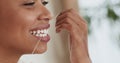 Young black woman flossing her teeth with tooth floss at home, close up portrait