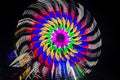 Intentional camera movement, slow shutter Zoom blur image of giant Ferris wheel illuminated and spinning at night in a funfair Royalty Free Stock Photo