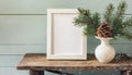 inter still life. Horizontal white frame mockup on vintage wooden bench, table. Modern white ceramic vase with pine tree branches Royalty Free Stock Photo