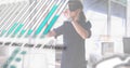 Interacting woman wearing VR headset manipulating floating data charts in open office, with laptop Royalty Free Stock Photo