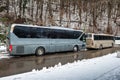 Intercity buses parked near the mountain forest at winter Royalty Free Stock Photo