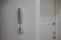 The intercom receiver hangs on the white wall next to the front door Royalty Free Stock Photo