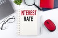 INTEREST RATE text on a notepad with laptop on the white background Royalty Free Stock Photo