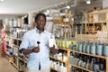 Interested african american man choosing bathroom accessories in store Royalty Free Stock Photo