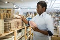 Interested african american man choosing plates in dishware store