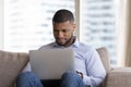 Interested African man use laptop spend leisure on internet