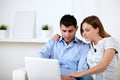 Interested couple browsing on laptop