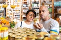 Interested couple reading product label on jar in supermarket