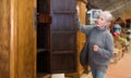 Elderly woman looking for wooden wardrobe in furnishing store Royalty Free Stock Photo