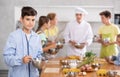 Interested teenager participating in culinary class of children group