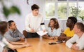 Guy discussing study topics with male coursemates at table Royalty Free Stock Photo